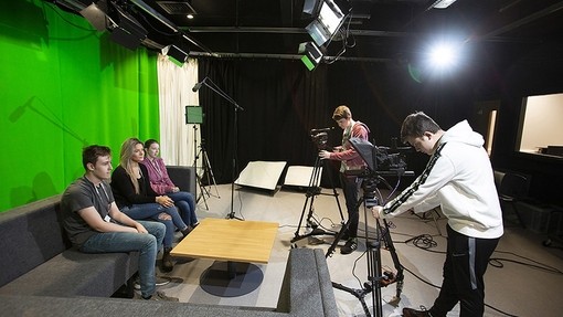 Sixth form students filming other students in a studio with green screen