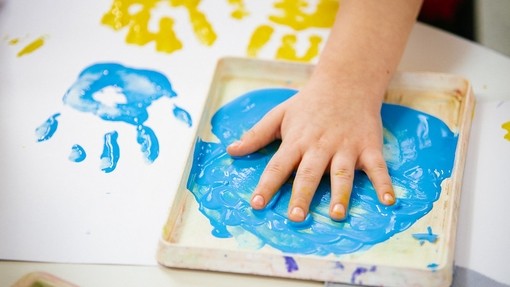 Child hand on painting