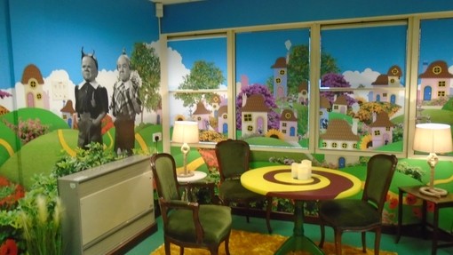 A creative corner of Race Leys Junior School's library with vibrant colourful walls and a table and chairs in the corner 