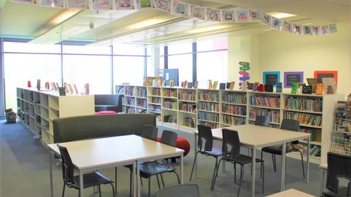 The Victory Academy school library with desks and book shelves 