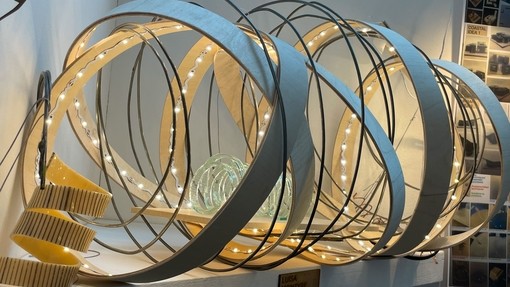 An image of some abstract 3D Art, large circles are intertwined with fairy lights. 