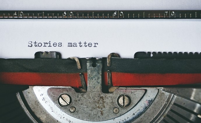 Close up photo of a page on the typewriter that says 'Stories matter'