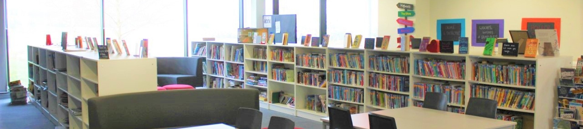 The Victory Academy school library with desks and book shelves 