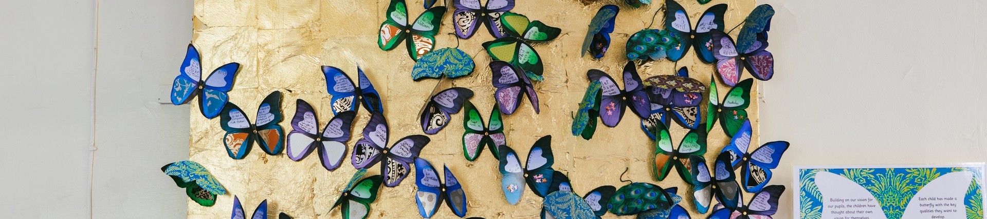 Description: Arts activity at Horningsham Primary School. A wall full of butterflies made out of paper. 