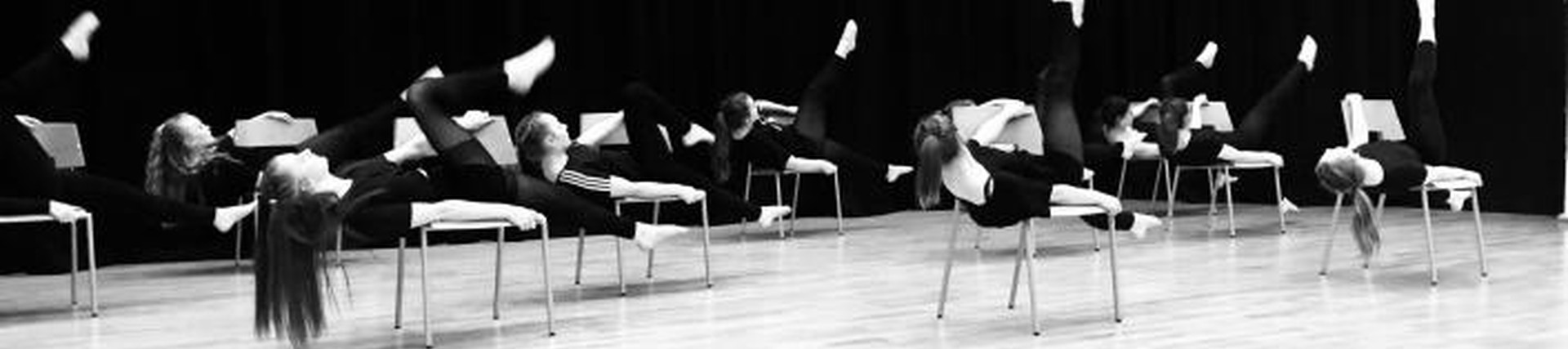 Black and white photo of students performing a dance piece on stage
