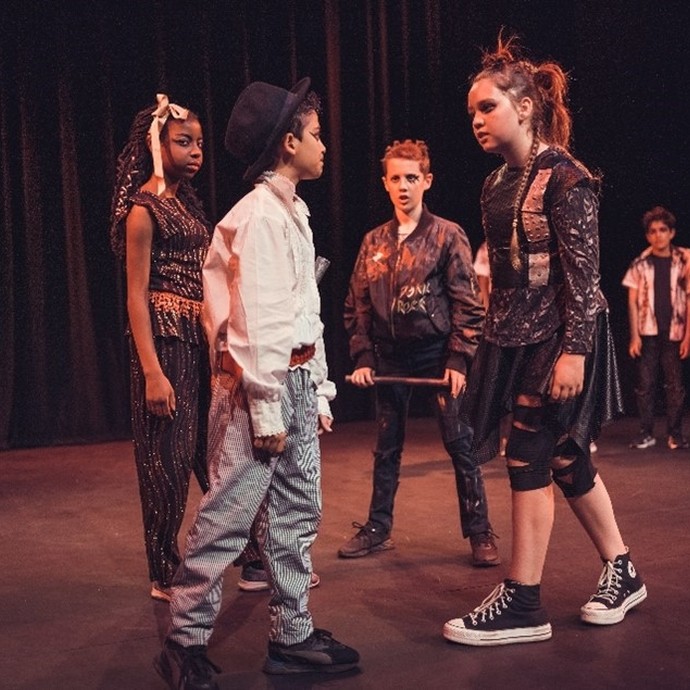 Young people acting on stage in costume